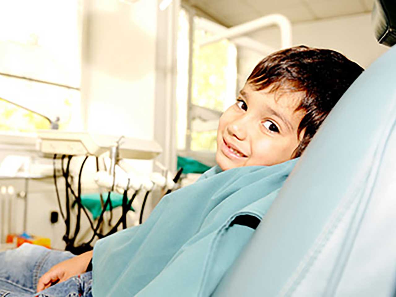 boy in dentist chair looking at camera