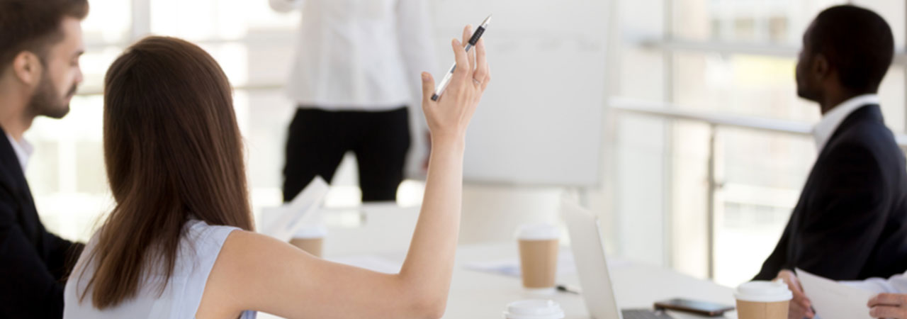 woman raising hand in business meeting