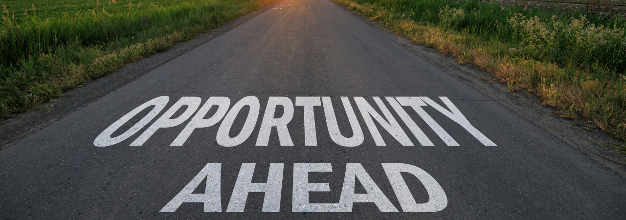 Road leading toward sunset with text that says "opportunity ahead"