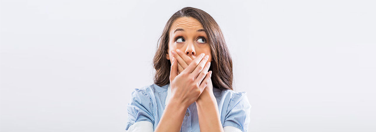 Exasperated woman covering her mouth.