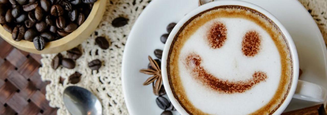 smiling face in coffee foam with coffee cup and coffee beans