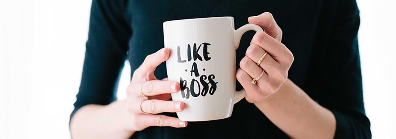Close up of female hands holding mug with text "like a boss"