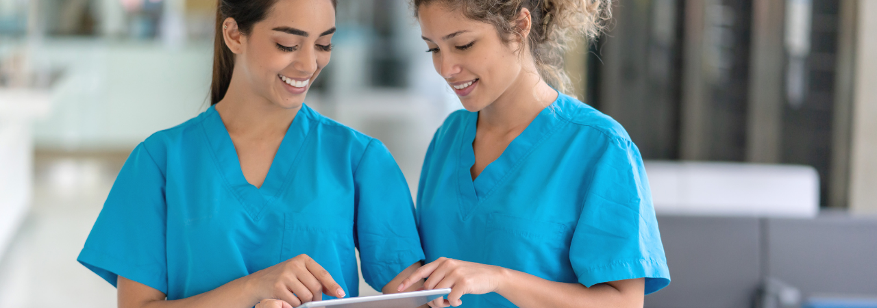 dental assistants talking and looking at a tablet