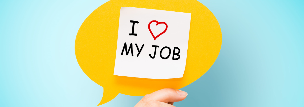 a hand holding a paper speech bubble that says "I love my job"