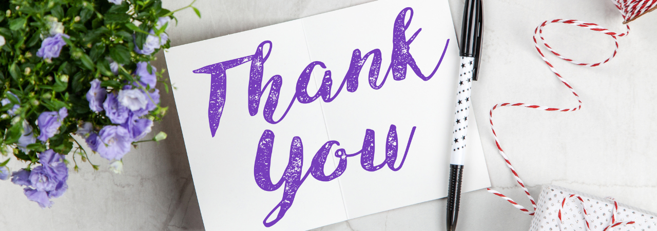 thank-you note in purple cursive text with flowers and a present in the background