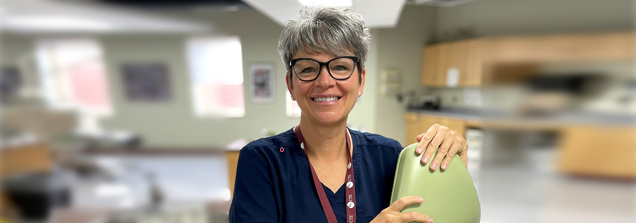 Dental assisting instructor Beth Ladd poses for a photo in a dental lab