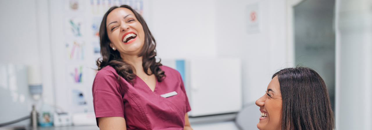 dental assistant and patient share a laugh