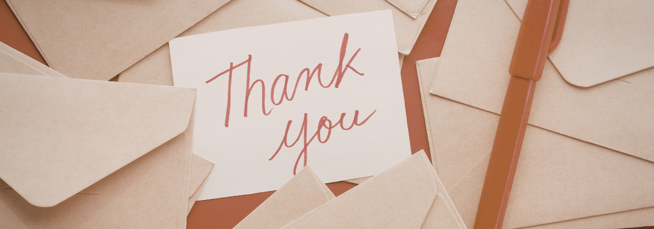 a card that says "thank you" with envelopes surrounding it