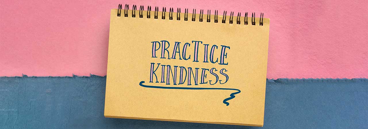 a notebook with text that reads "practice kindness"