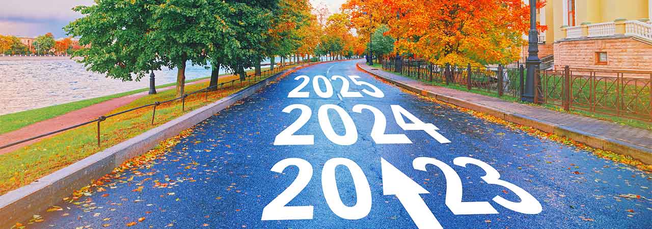 a road with arrows pointing ahead to upcoming years: 2023, 2024, and 2025