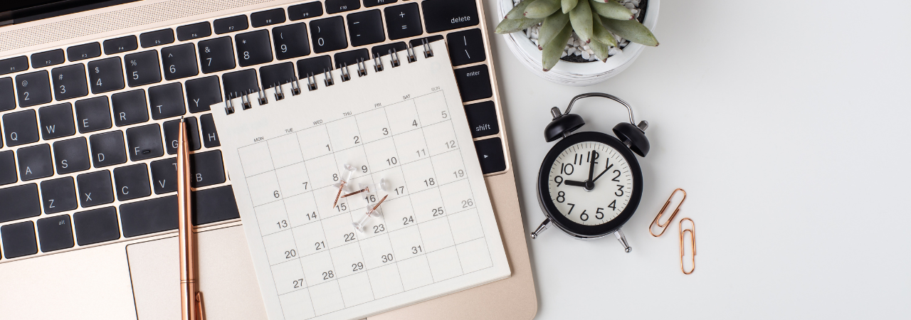 calendar next to a laptop and clock