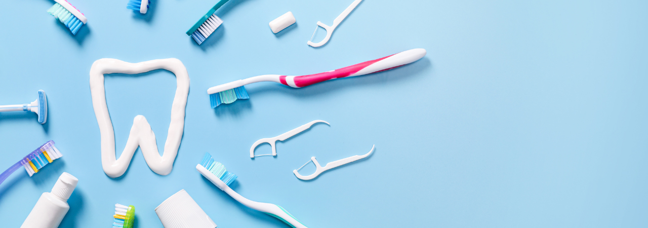 Toothbrushes and floss picks circled around a tooth made of toothpaste