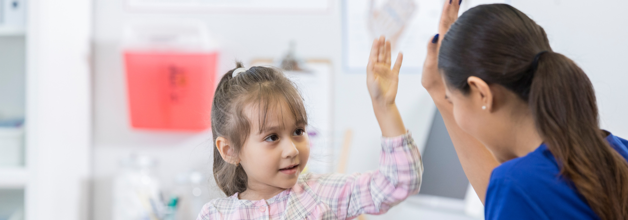 dental assistant giving young patient a high five