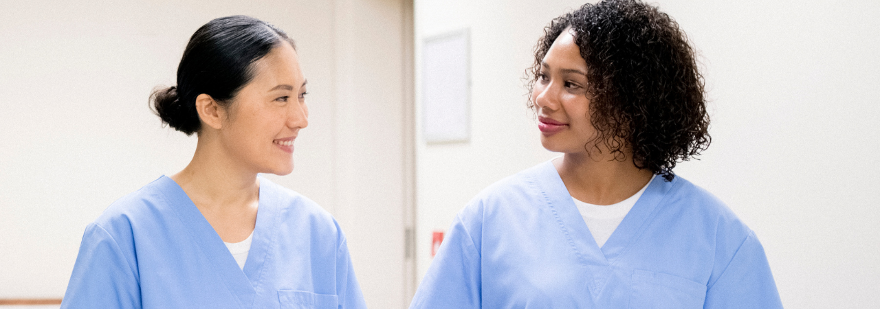 two dental assistants looking at each other and smiling