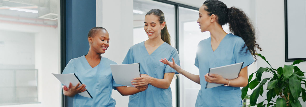 dental assistants in scrubs looking at notebooks