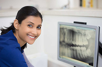 female dental assistant with radiographic image on monitor