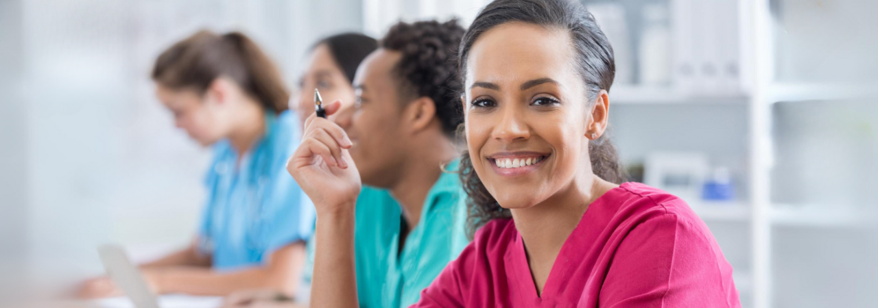 Smiling dental assistant looks at camera