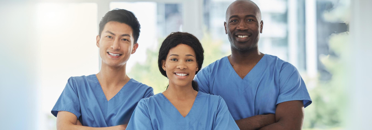 three dental professionals in scrubs