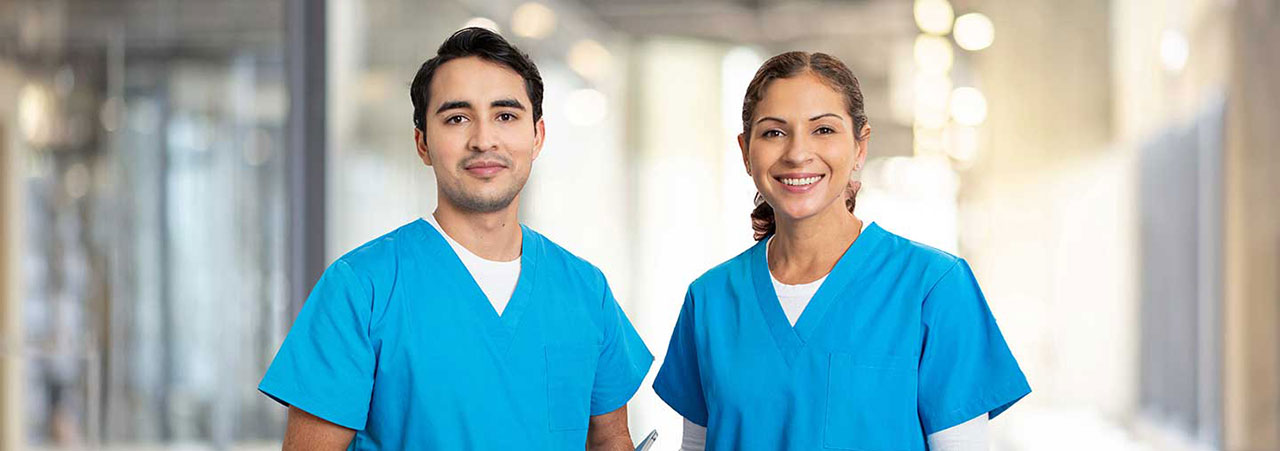 Two dental assistants in scrubs