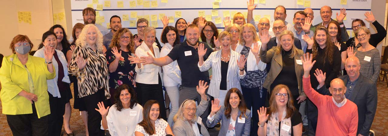 Group photo of forum participants waving