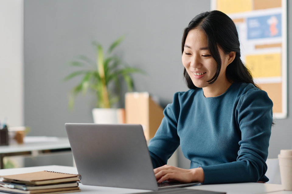 smiling woman studying on laptop