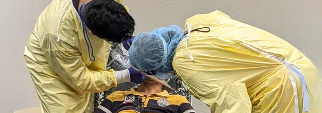 Free dental clinic volunteers examining patient