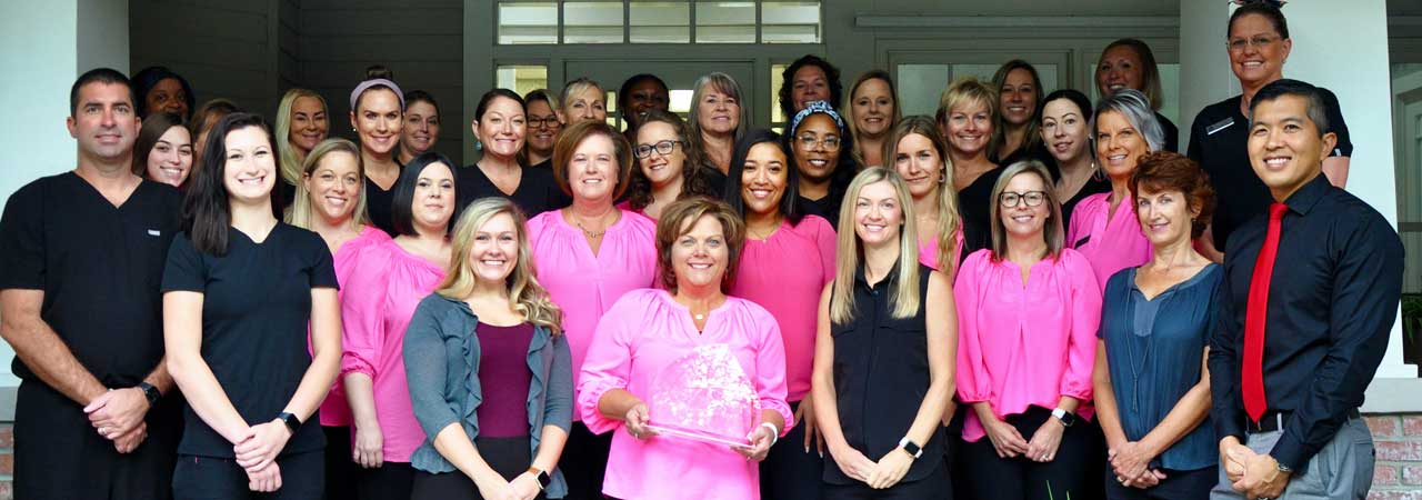 Teresa Spence holding her award and her dental colleagues